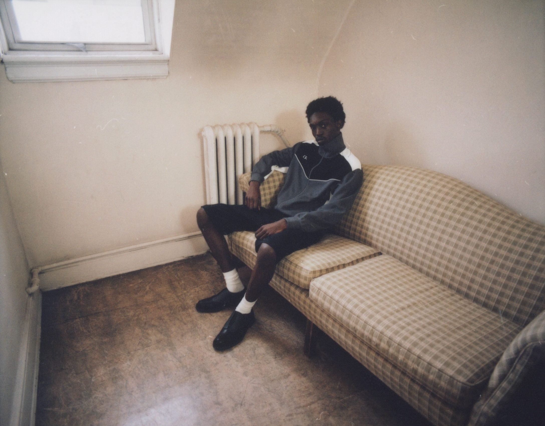 Grey half-zip and black shorts on a checked sofa